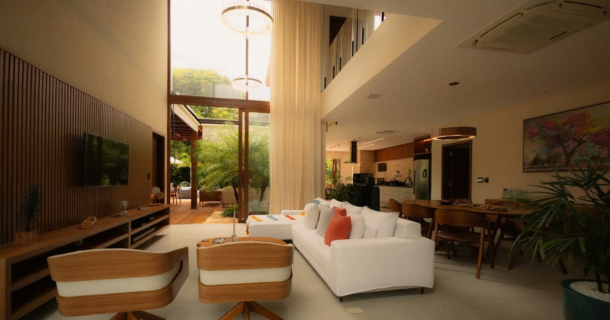 Sala de estar moderna e espaçosa com janelas grandes, evocando o tipo de imóvel de temporada que esses sistemas de gestão precisam atender