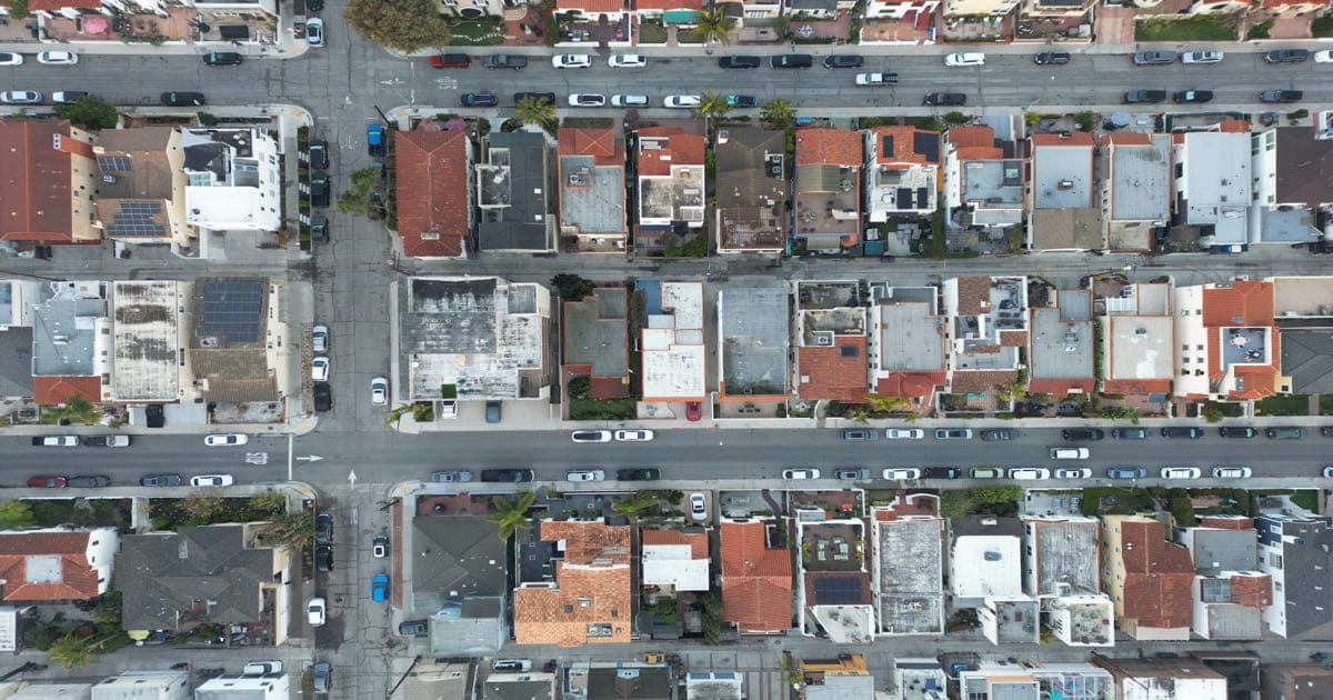 Vista aérea de um bairro residencial com muitas casas, evocando o salto de portfólio que acontece quando a operação supera a barreira dos 10 imóveis